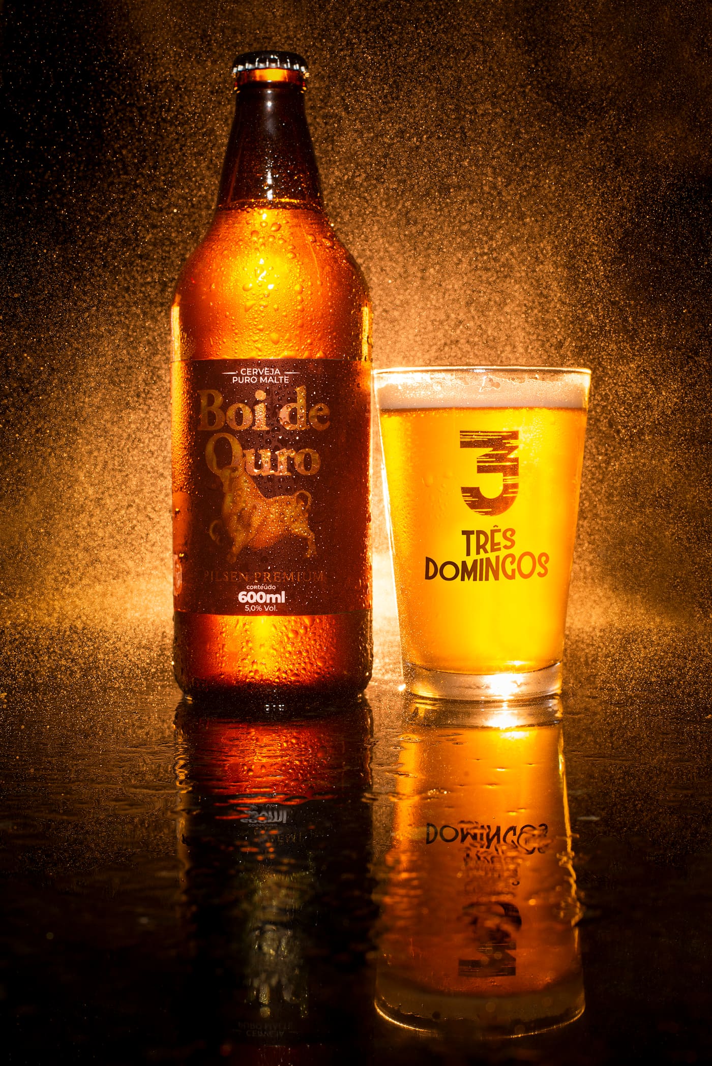 Garrafa de Boi de Ouro ao lado de copo Três Domingos com cerveja dourada